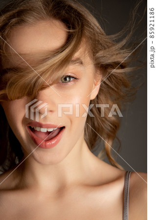 Close-up portrait of young beautiful girl with day makeup isolated over gray studio background. Natural beauty concept. Close-up portrait of young beautiful girl with day makeup isolated over gray studio background. Natural beauty concept. 85921186