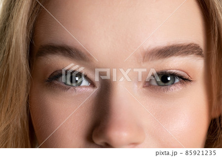 Cropped close-up face of young beautiful well-kept skinned girl without makeup. Facial expression, cosmetics, natural beauty concept. 85921235