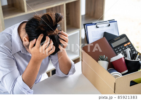 Images of business woman carrying packing up all his personal belongings and files into a brown cardboard box has frustrated and stressed to resignation and signing cancellation contract letter 85921383