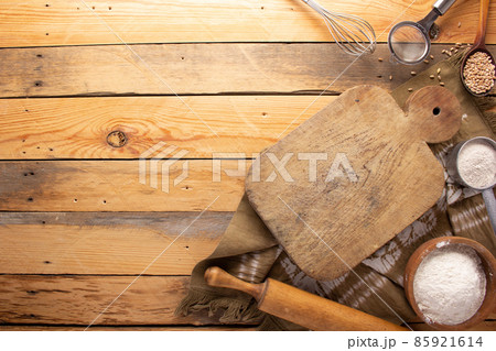 Cutting board and scattered flour powder on wood background top table Cutting board and scattered flour powder on wood background top table 85921614