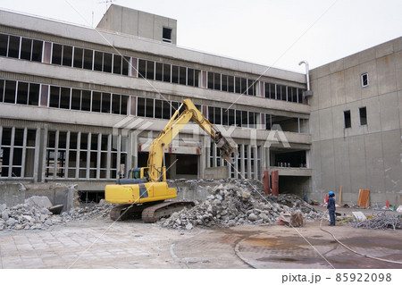 老朽化した公共建造物の解体作業をする重機 85922098