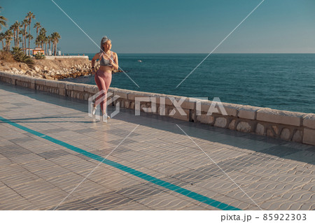 Slender lady actively running by the waterfront 85922303