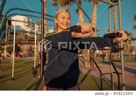 Sporty woman exercising outside with rubber bands 85922304