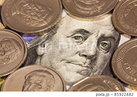 100 dollars banknote and white coins. A portrait of Roosevelt Franklin on a hundred dollar bill framed by silver coins. Money concept for financial and business news. Close-up 100 dollars banknote and white coins. A portrait of Roosevelt Franklin on a hundred dollar bill framed by silver coins. Money concept for financial and business news. Close-up 85922882