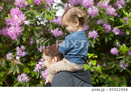 Little caucasian girl sitting shoulders his mother Little caucasian girl sitting shoulders his mother 85922998