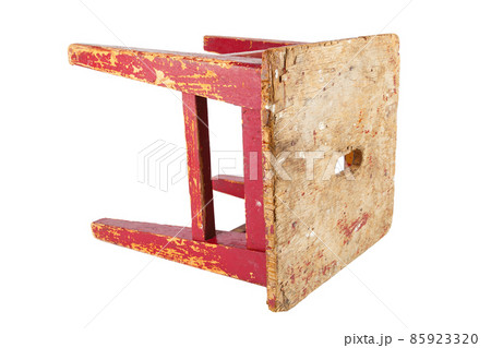 Old wooden stool with peeling red paint. Loft style chair isolated on a white background. 85923320