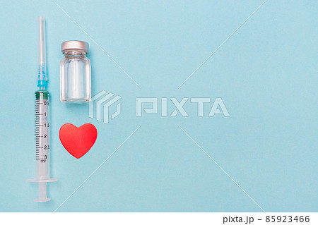 Syringe, heart, covid 19 vaccine and medical mask on a blue background. Keep your health. Vaccination. Medical treatment concept. Flat lay. Immunity. Copy space. Place for text. Syringe, heart, covid 19 vaccine and medical mask on a blue background. Keep your health. Vaccination. Medical treatment concept. Flat lay. Immunity. Copy space. Place for text. 85923466