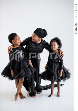 Mother and daughters in elegnat clothes posing indoors 85924901
