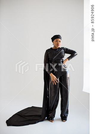 African woman in black evening wear posing indoors 85924906