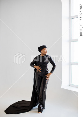 African woman in hijab and black evening wear posing indoors 85924907
