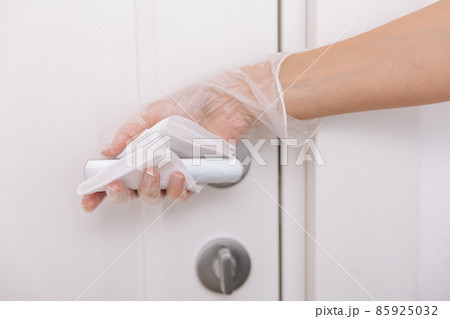 Cleaning door handles with wet wipe and white gloves. Woman hand using towel for cleaning home room door link. Sanitize surfaces prevention in hospital and public spaces against corona virus. Cleaning door handles with wet wipe and white gloves. Woman hand using towel for cleaning home room door link. Sanitize surfaces prevention in hospital and public spaces against corona virus. 85925032