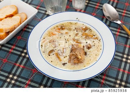 Soup with mushroom and pork served with sour cream 85925938