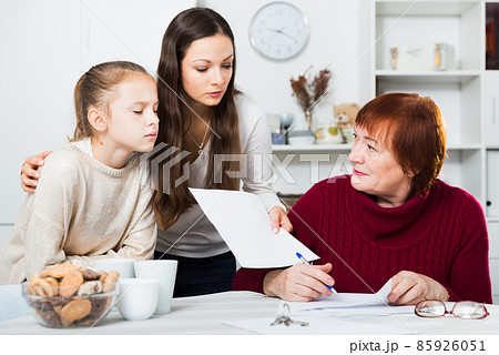 Adult daughter controlling signing of documents by grandmother Adult daughter controlling signing of documents by grandmother 85926051