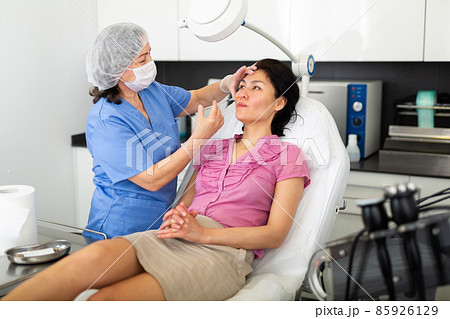 Cosmetologist giving beauty injections for face skin to female client 85926129