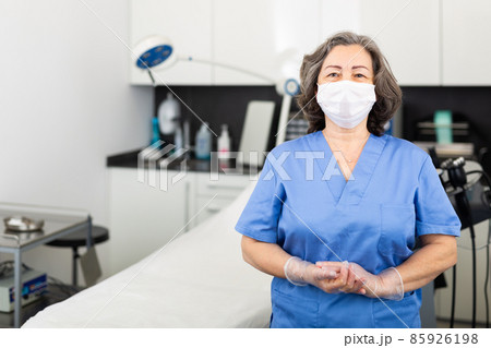Nurse in protective mask waiting for the patient to the procedure in esthetic clinic Nurse in protective mask waiting for the patient to the procedure in esthetic clinic 85926198