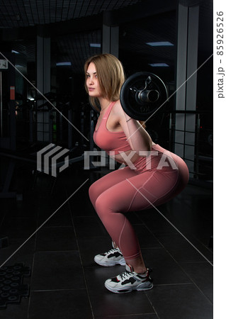 beautiful girl doing exercises with a barbell in the gym. beautiful girl doing exercises with a barbell in the gym. 85926526