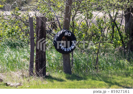 No Trespassing tire sign on barb wire fence  85927161