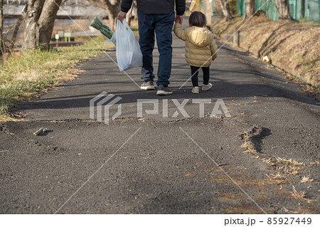 買い物袋を持ち子供と歩く男性の後ろ姿 買い物袋を持ち子供と歩く男性の後ろ姿 85927449