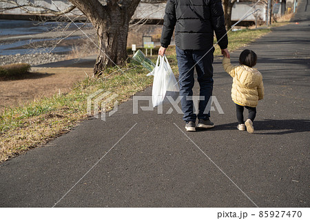 買い物袋を持ち子供と歩く男性の後ろ姿 買い物袋を持ち子供と歩く男性の後ろ姿 85927470