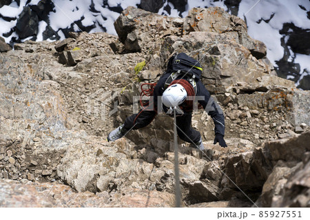 Climber is rappeling from the mountains summit. 85927551