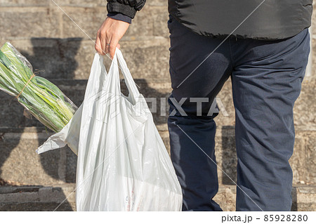 買物袋をさげて歩く男性の様子 買物袋をさげて歩く男性の様子 85928280