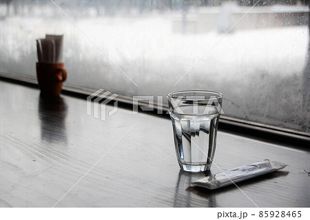 カフェの窓辺に置かれたお冷グラスとおしぼり カフェの窓辺に置かれたお冷グラスとおしぼり 85928465
