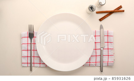 Empty white ceramic plate mockup with cutlery. 85931626