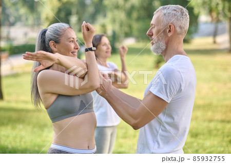 Male instructor checking the correctness of the exercise Male instructor checking the correctness of the exercise 85932755