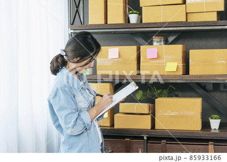 Woman checking stock goods supply delivery package shipping use document checklist. Asian woman startup small business at home office. Online entrepreneur asian woman use tablet checking online order Woman checking stock goods supply delivery package shipping use document checklist. Asian woman startup small business at home office. Online entrepreneur asian woman use tablet checking online order 85933166
