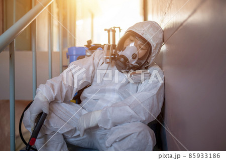 Tired, health workers wear PPE, spraying disinfectants to prevent the spread of germs or coronavirus. 85933186