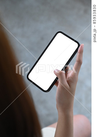 Close up view young woman hand holding smart phone with white empty screen. 85933830