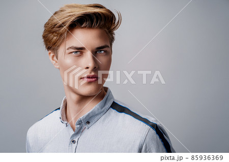 portrait of handsome young guy wearing shirt while looking at camera. Stylish hairstyle.  85936369