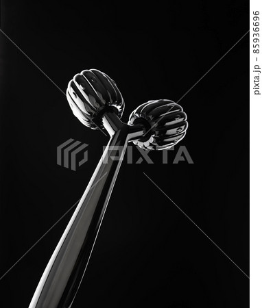 Y-shaped ball roller for face massage on black background. Facial massager 85936696