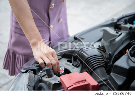 Woman trying to fix her broken vehicle. Woman trying to fix her broken vehicle. 85936740