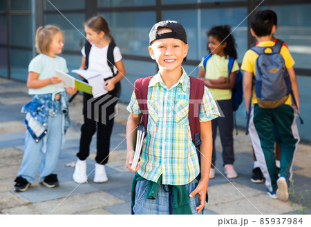 Smiling primary school boy standing outdoors 85937984