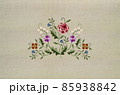 Bouquet of twigs with small white flowers, violets, poppies, twigs with blue flowers and a red-pink rose in the middle on a beige fabric background. 85938842