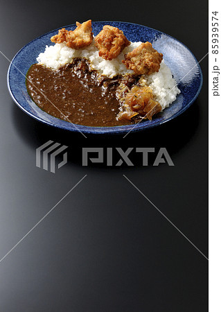 福神漬けも乗っている唐揚げカレーを黒背景で撮影 85939574