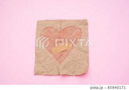 love concept - torn red heart on paper glued with plaster on a pink background. Broken love concept love concept - torn red heart on paper glued with plaster on a pink background. Broken love concept 85940171