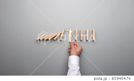 Silhouette of a paper man against the risk of a domino effect 85940474