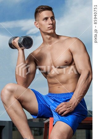 Man doing heavy weight exercise with dumbbells in gym Man doing heavy weight exercise with dumbbells in gym 85940751