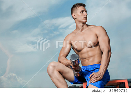 Muscular man doing heavy weight exercise for biceps with dumbbells Muscular man doing heavy weight exercise for biceps with dumbbells 85940752