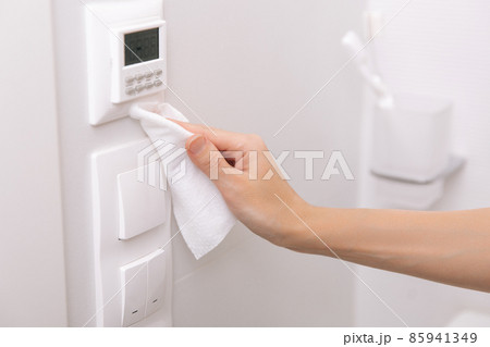 Cleaning switches and sockets with a microfiber cloth. Sanitize surfaces prevention in hospital and public spaces against corona virus. Woman hand using wet wipe for cleaning home room door link. Cleaning switches and sockets with a microfiber cloth. Sanitize surfaces prevention in hospital and public spaces against corona virus. Woman hand using wet wipe for cleaning home room door link. 85941349