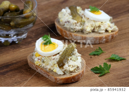 Fish pate over brown bread with egg and pickles. Fish pate over brown bread with egg and pickles. 85941932