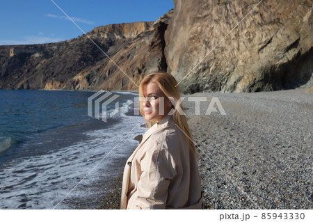 portrait of a young beautiful woman on the seashore against the background of rocks portrait of a young beautiful woman on the seashore against the background of rocks 85943330