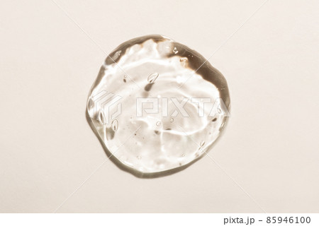 Transparent hyaluronic acid gel drop on a beige background. 85946100