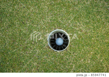 a golf ball in to the hole 85947741