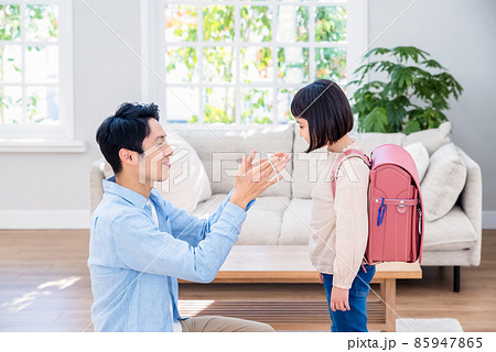 小学生の娘にマスクをする父親 小学生の娘にマスクをする父親 85947865
