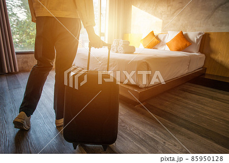 Cropped shot of tourist woman pulling her luggage to her hotel bedroom after check-in. Conceptual of travel and vacation. 85950128