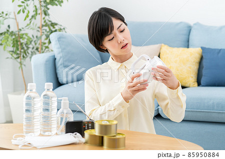 自宅で防災用品・避難用品・非常食の備蓄を確認する女性 85950884
