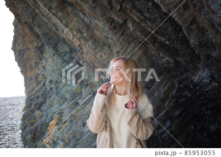 portrait of a young beautiful woman on the seashore against the background of rocks portrait of a young beautiful woman on the seashore against the background of rocks 85953055